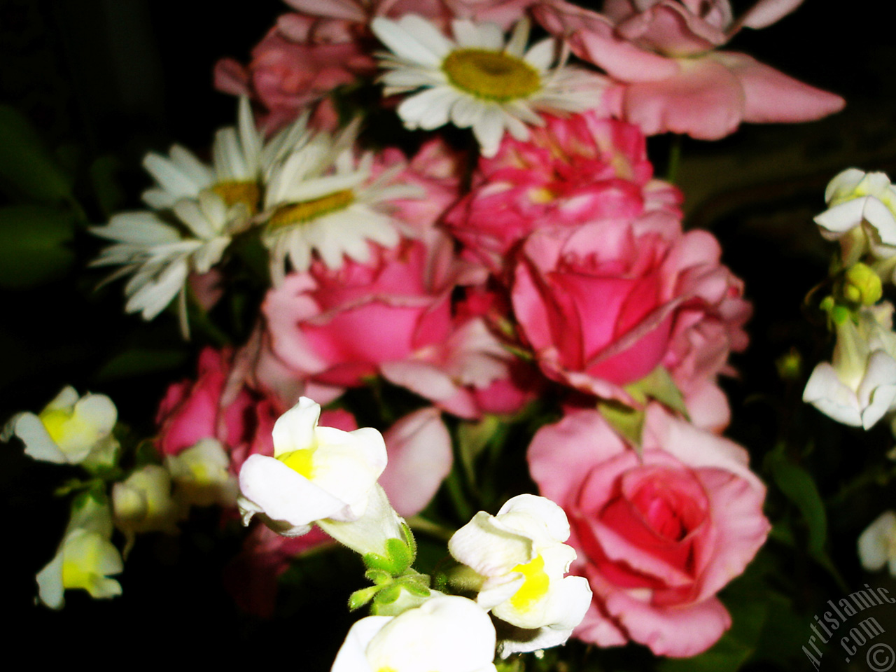 A bouquet consisting of rose, daisy and snapdragon flowers.
